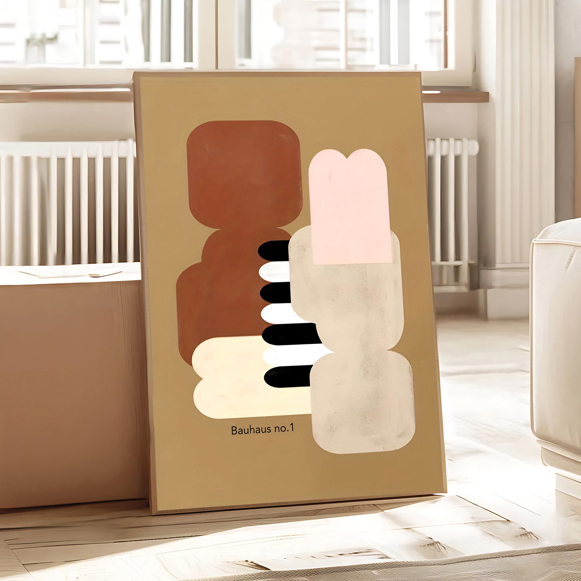 Framed abstract artwork with geometric shapes on a beige background, placed on a surface.