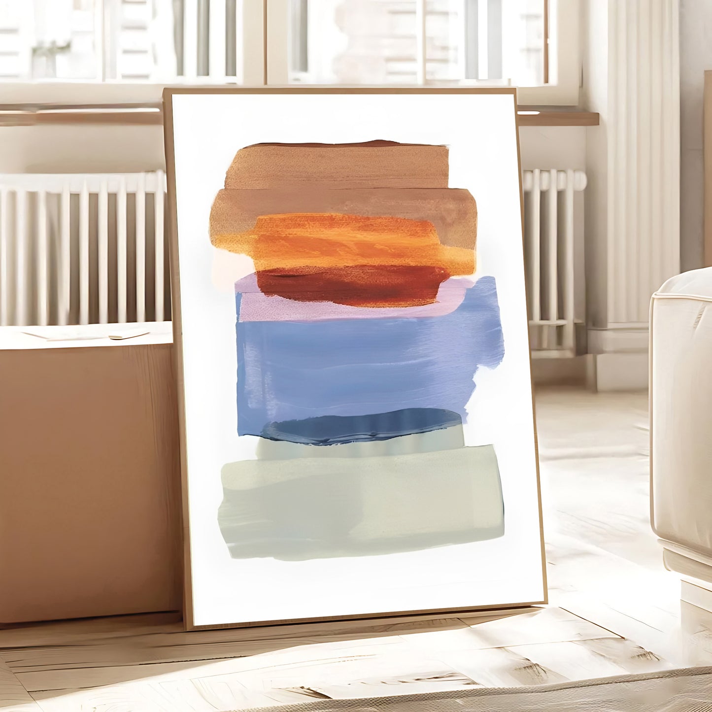 Abstract art print with colorful shapes in a gold frame on a light wooden floor.