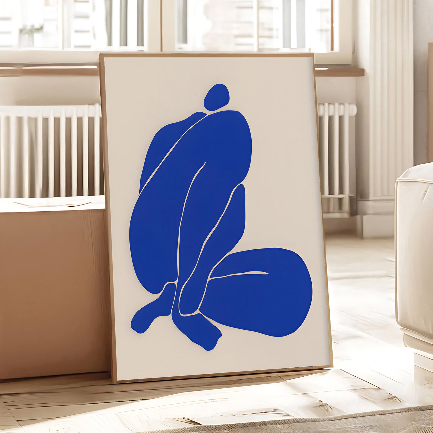 Abstract blue artwork on a white wall in a room with light-colored walls and a radiator.