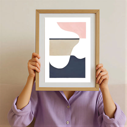 Person holding a framed abstract art print with a minimalistic design.