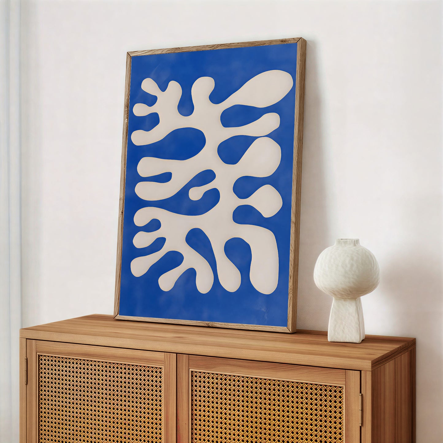 Abstract artwork with blue and white design on a wooden cabinet against a white wall