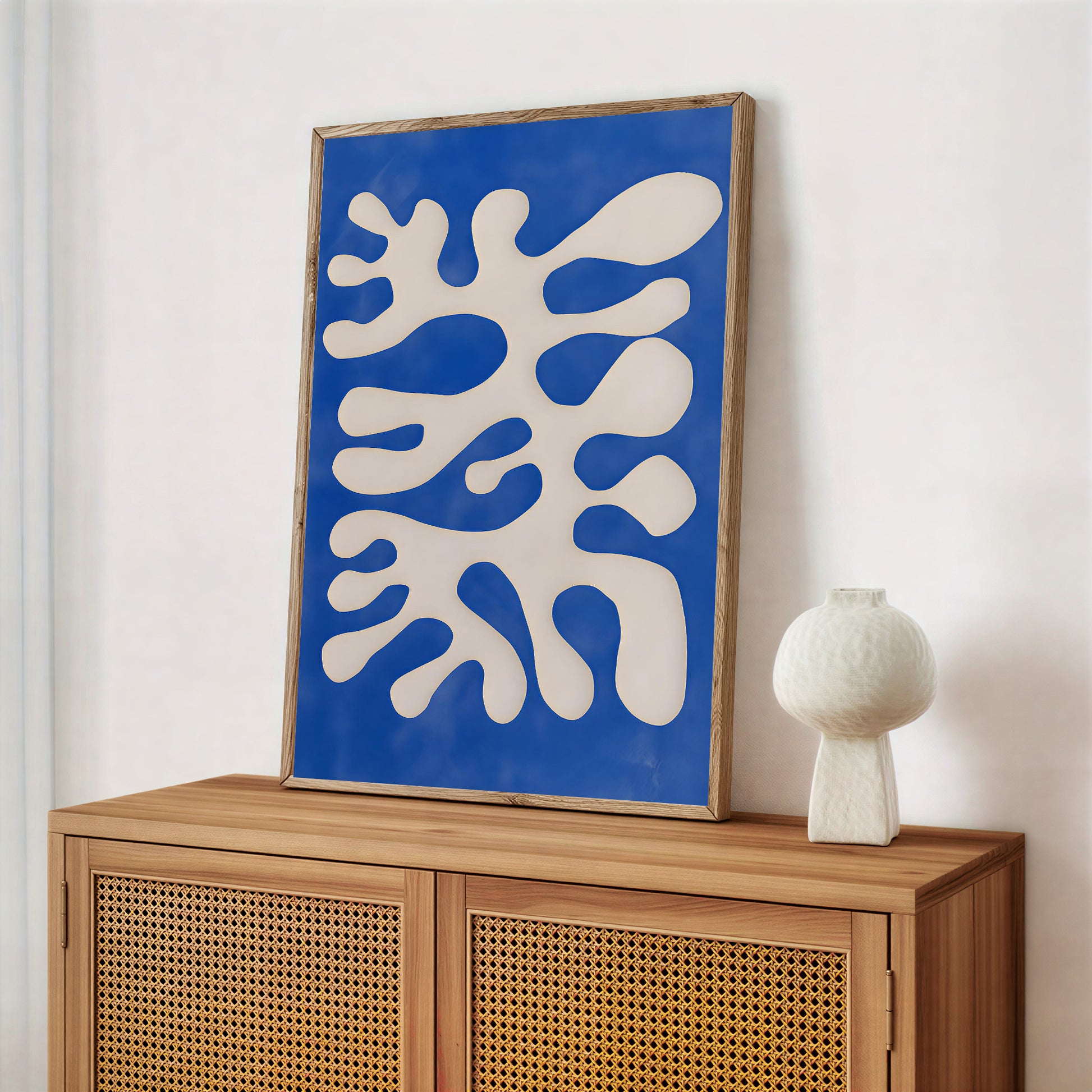 Abstract artwork with blue and white design on a wooden cabinet against a white wall
