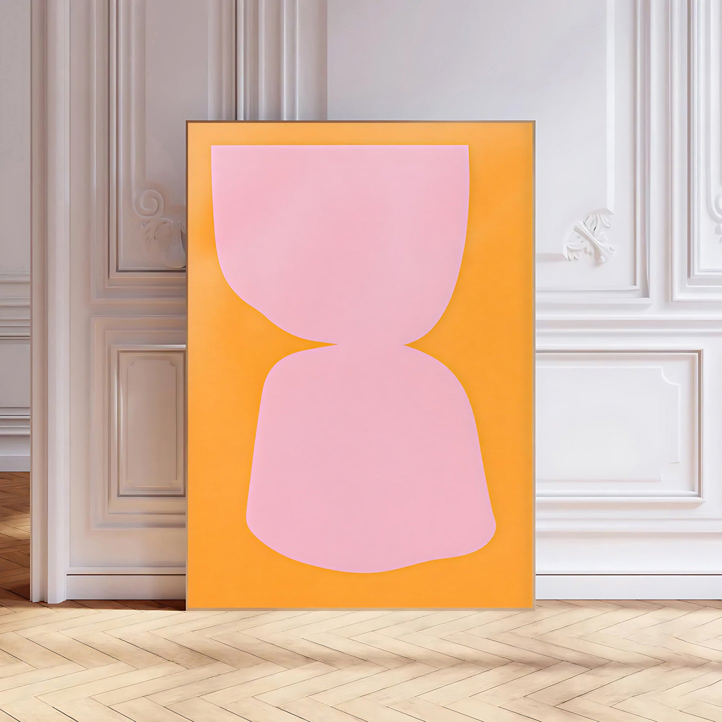 Abstract art print with a pink shape on an orange background in a room with white walls and wooden floor.