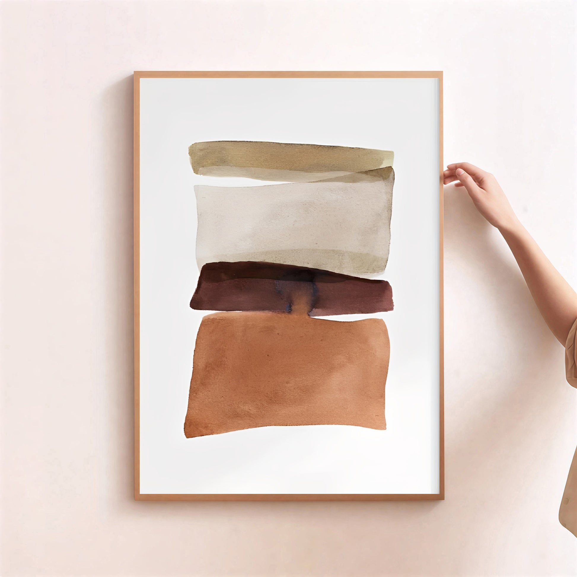 Framed abstract art piece with brown and beige colors on a light pink wall.
