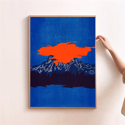 Framed abstract art print with orange and blue colors on a white wall.