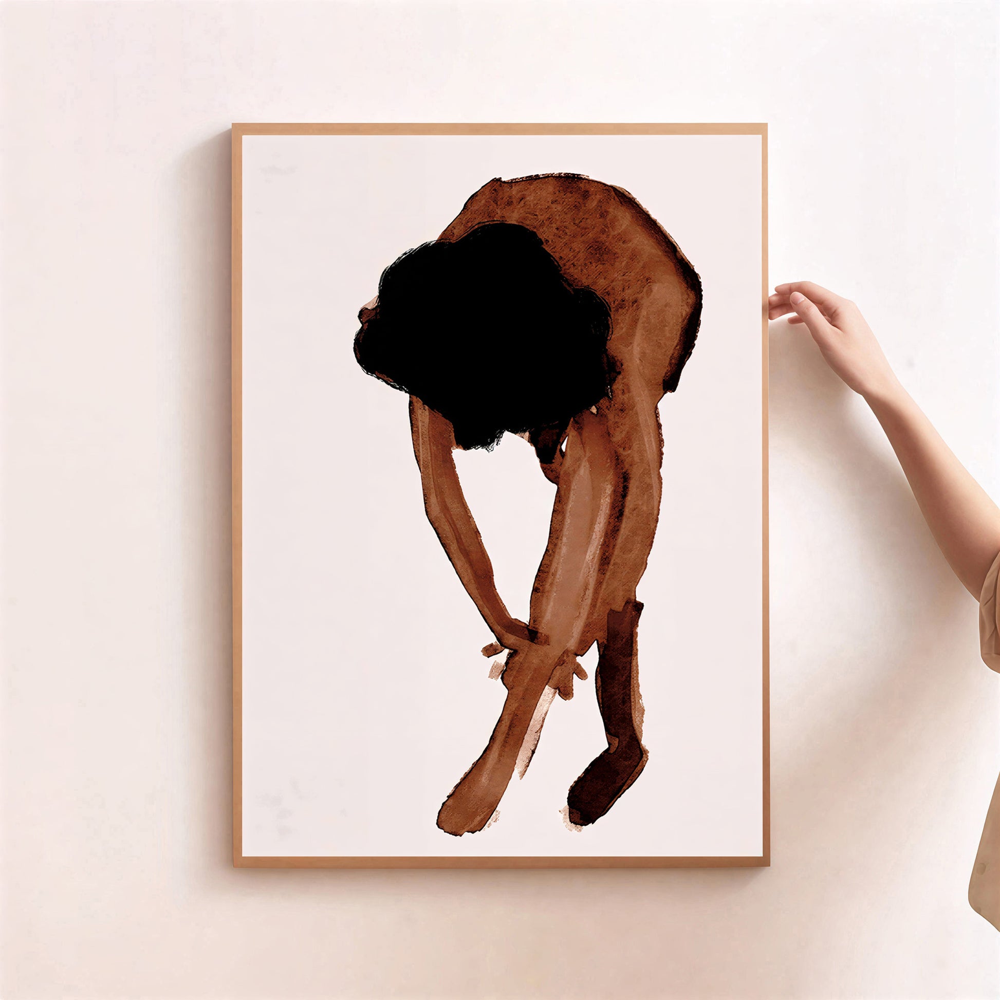 Framed artwork of a person in a crouched position on a light background
