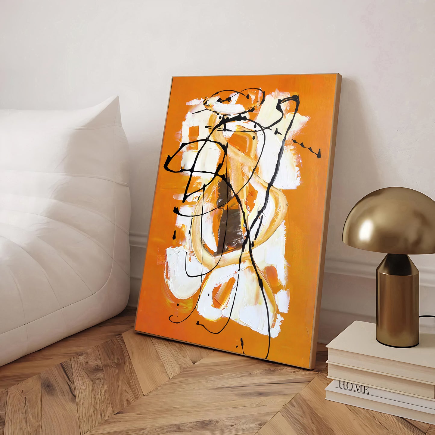 Abstract painting on an orange background in a room with a lamp and books.