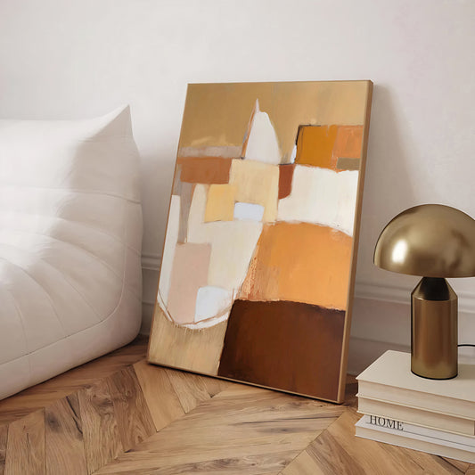 Abstract painting on a wooden floor with a lamp and books in the background