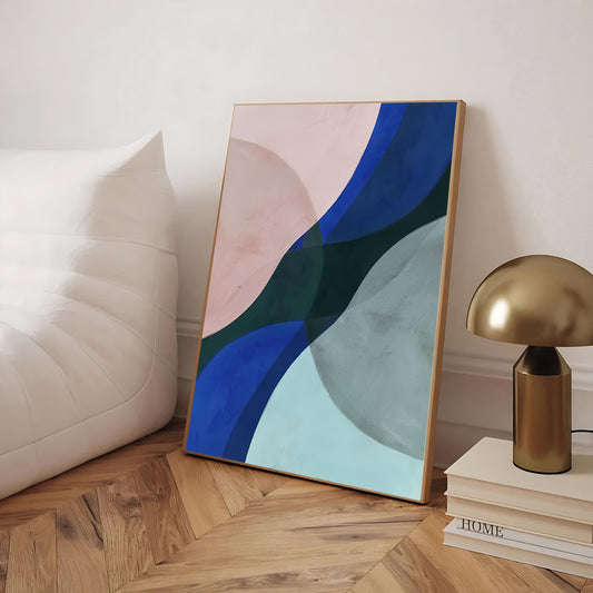 Abstract art piece on a wooden floor with a lamp and books in the background