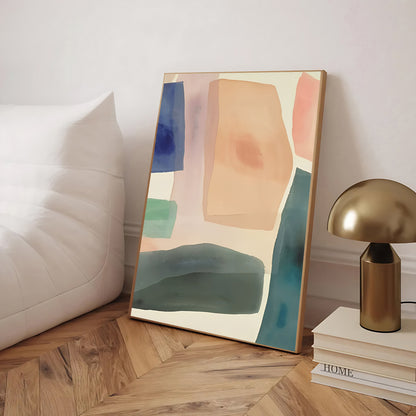 Abstract art piece on a wall next to a lamp and books on a wooden floor.