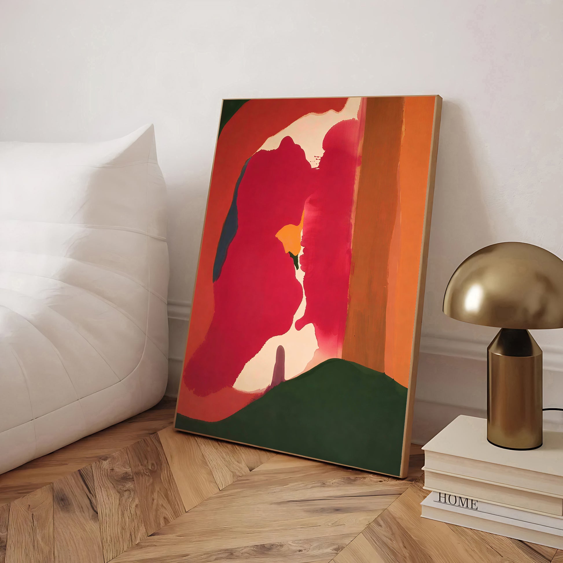 Abstract art piece on a wooden floor with a lamp and books in the background
