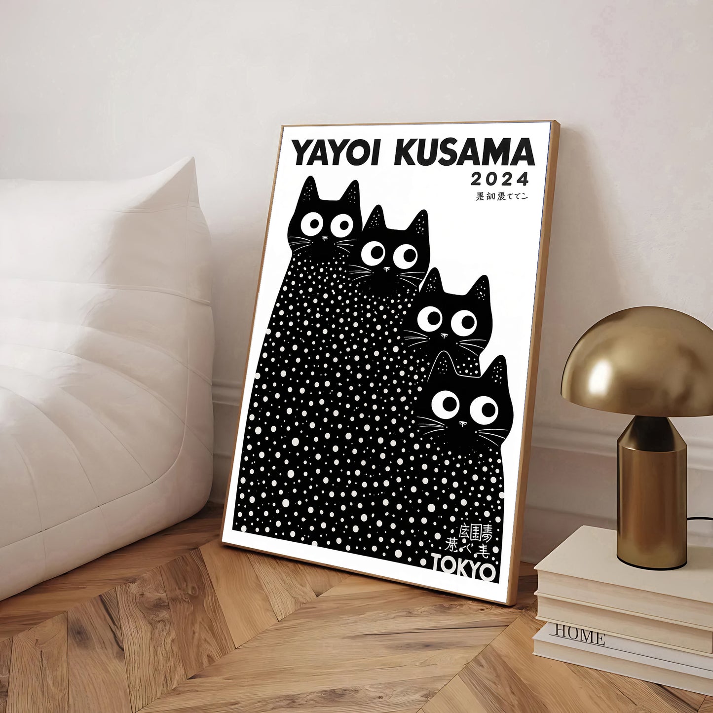 Framed Yayoi Kusama cats artwork with black cats design on a wooden floor.