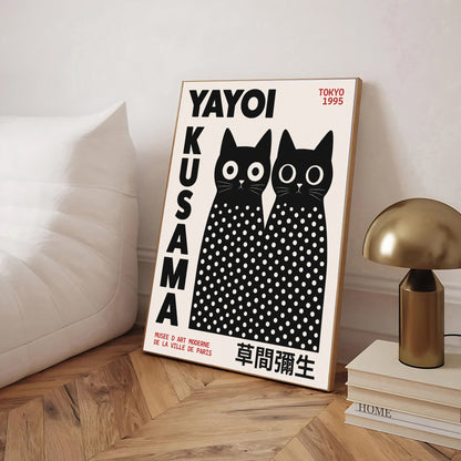 Framed Yayoi Kusama Inspired Black Cat Poster and text on a wooden floor.