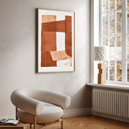 Modern interior with a beige armchair, abstract art, and a window with a view of trees.