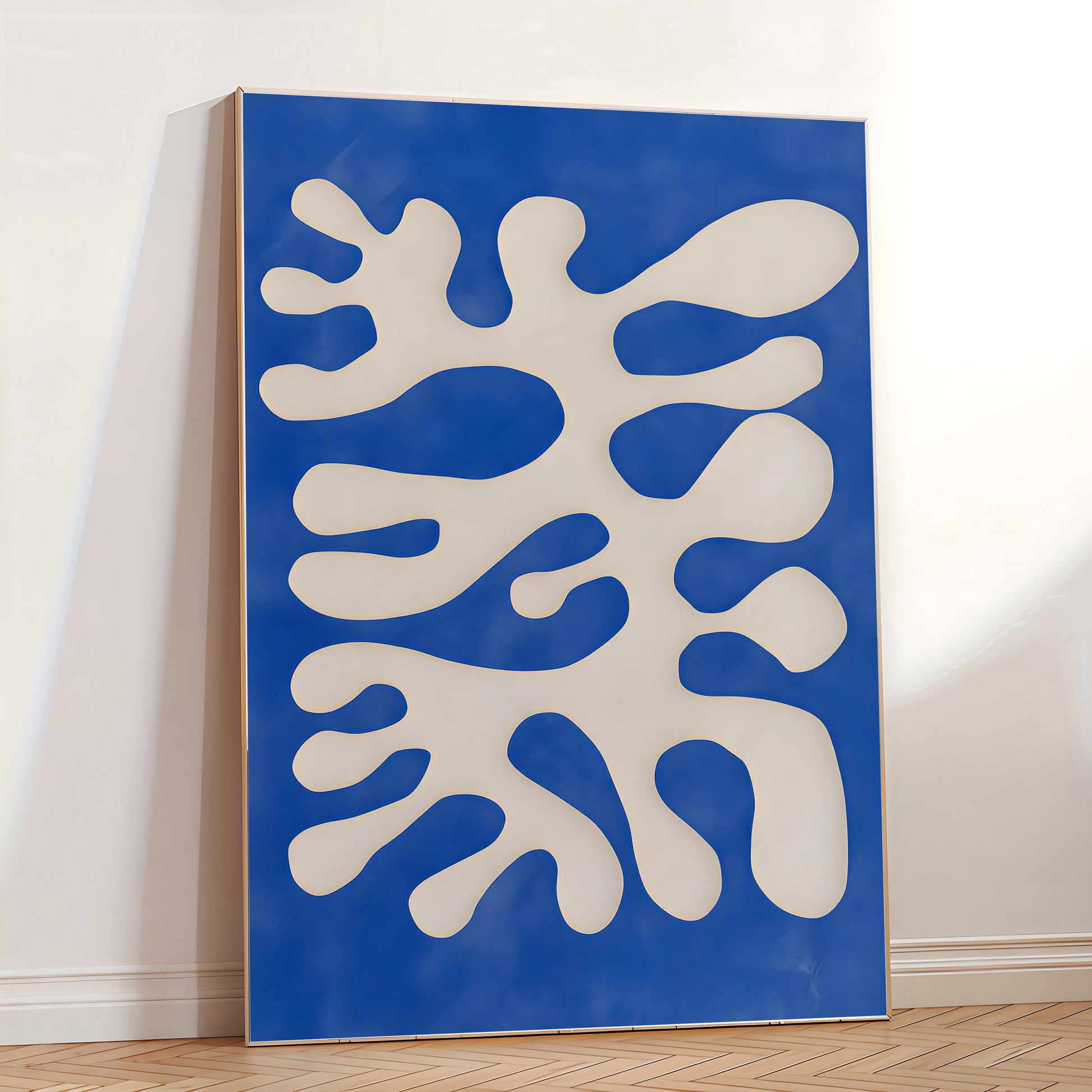 Abstract art piece with white shapes on a blue background in a room.