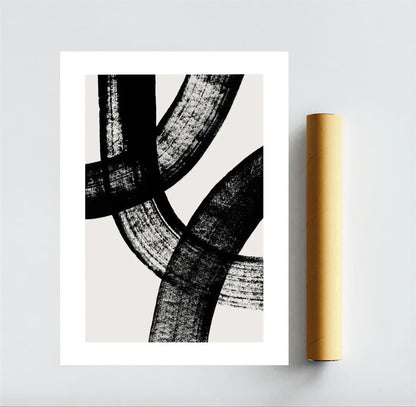 Abstract black and white art print on a gray background with a gold roll of paper.