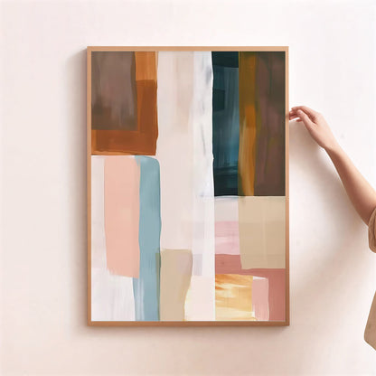 Abstract art print with colorful geometric shapes in a wooden frame on a light pink wall.