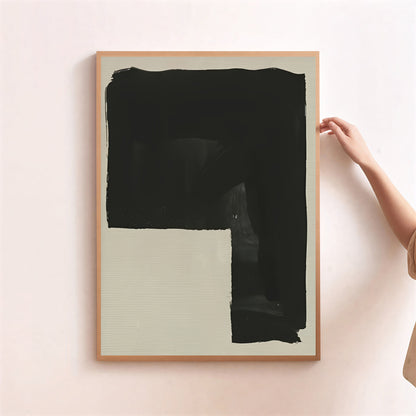 Framed abstract art piece with a large black brushstroke on a light background