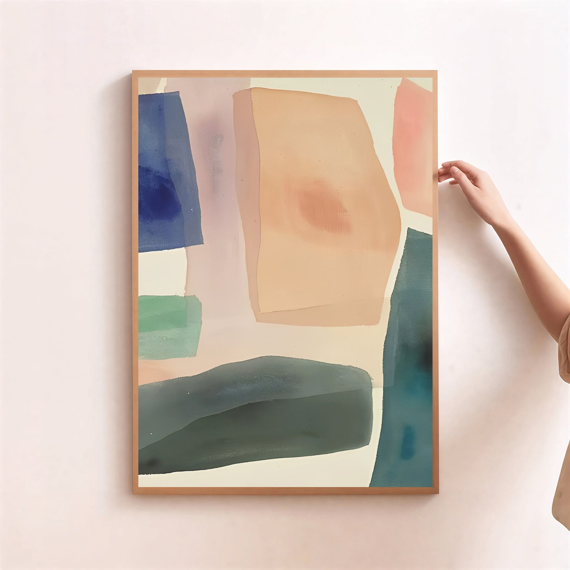 Abstract art print with colorful shapes on a light pink wall, held by a hand.