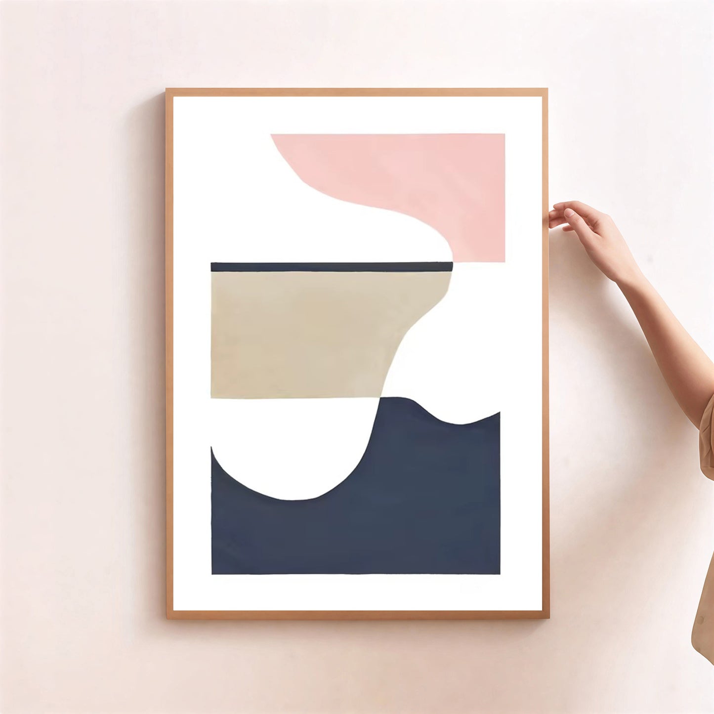 Abstract art print with geometric shapes in pink, beige, and navy on a light pink wall.
