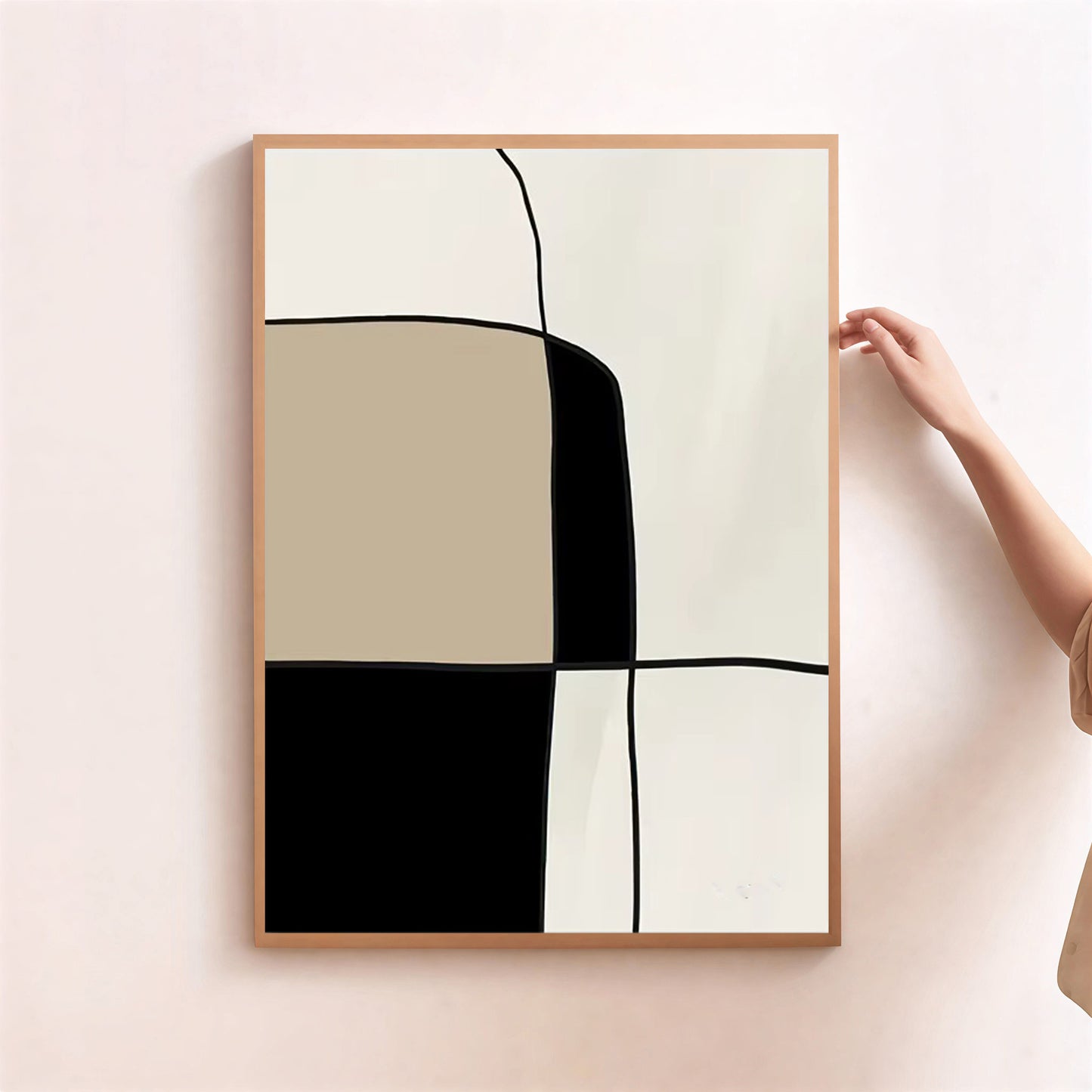 Abstract art print with geometric shapes in a wooden frame on a light pink wall.