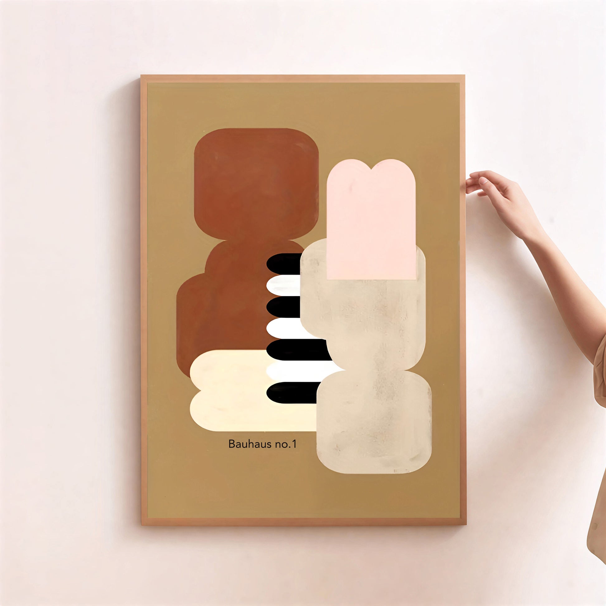 Abstract art print titled 'Bauhaus no.1' on a beige background with a hand holding the frame.