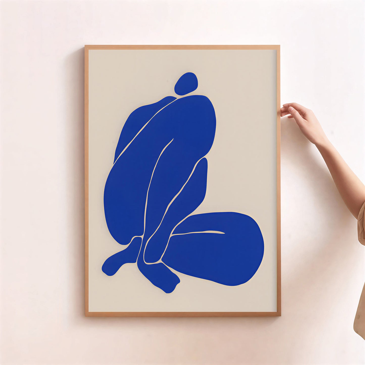 Framed abstract art print with a blue figure on a beige background