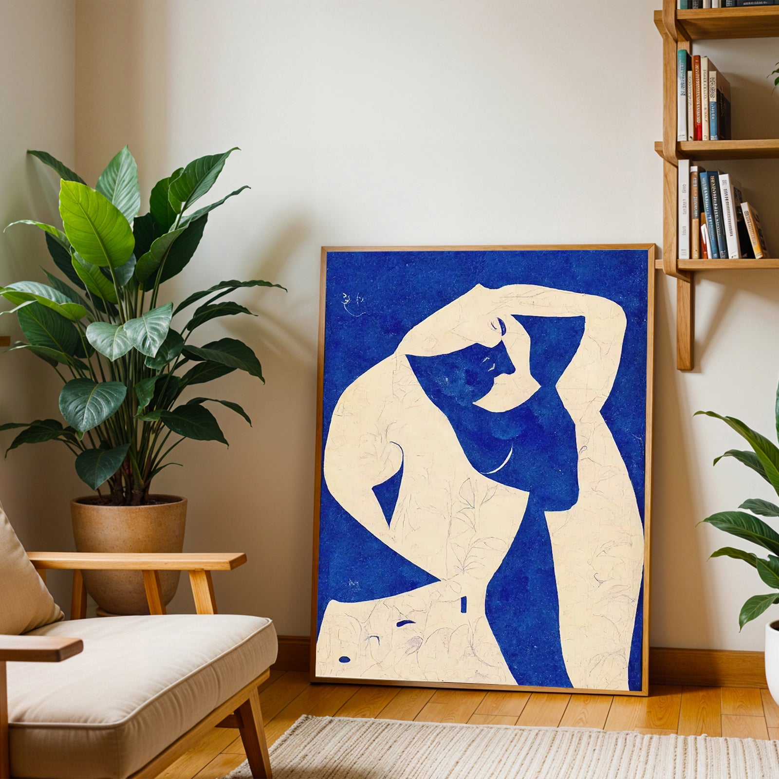 Framed abstract artwork of a nude figure on a wall in a living room with plants and a bookshelf.
