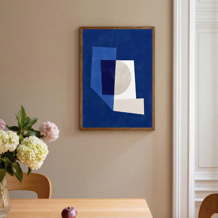 Abstract art print on a wall above a table with flowers