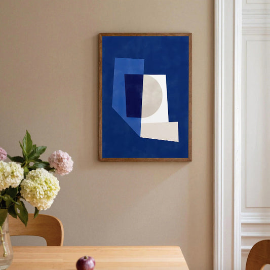 Abstract art print on a wall above a table with flowers