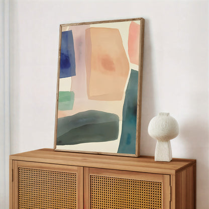 Abstract art piece on a wooden cabinet with a white vase.