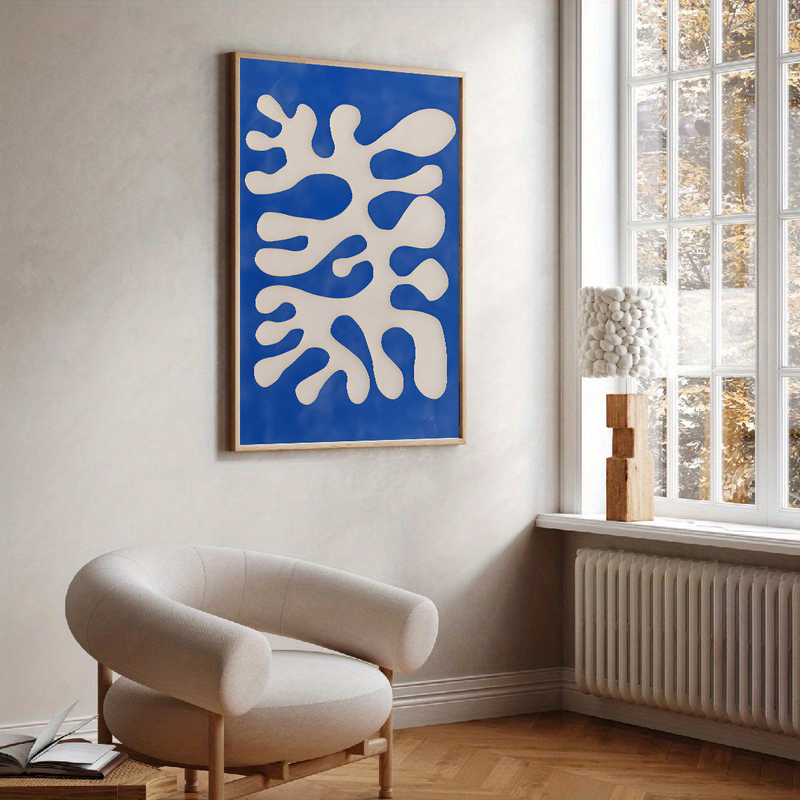 Modern living room with a blue abstract painting on the wall and a beige armchair.