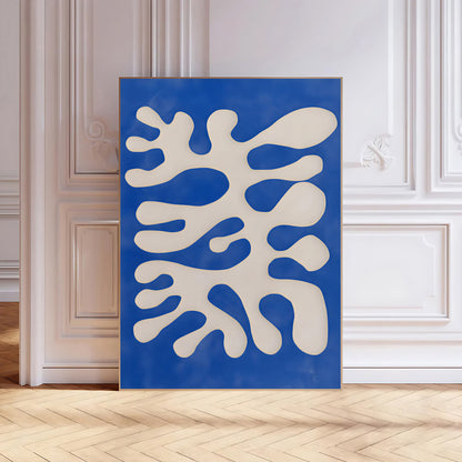 Abstract art piece with white shapes on a blue background in a room with wooden floor and white walls.