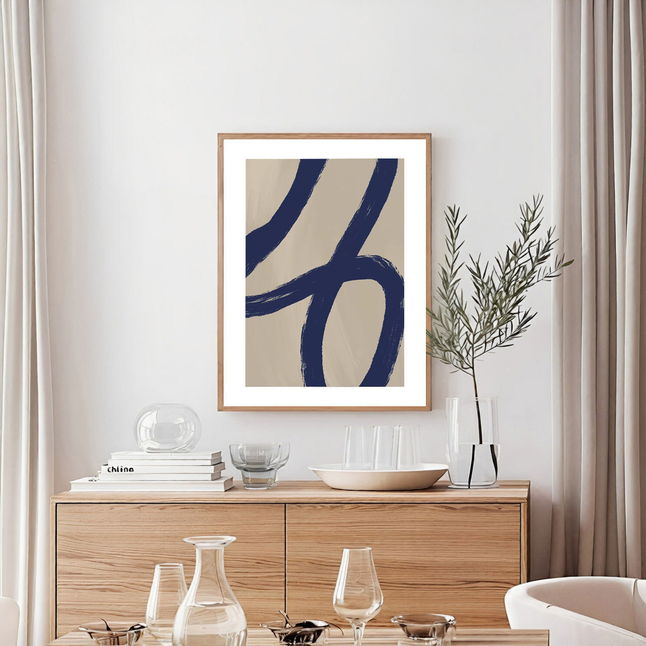 Framed abstract art on a wall above a wooden sideboard with decorative items.