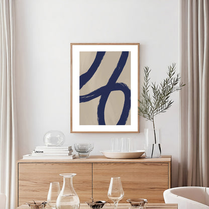 Framed abstract art on a wall above a wooden sideboard with decorative items.