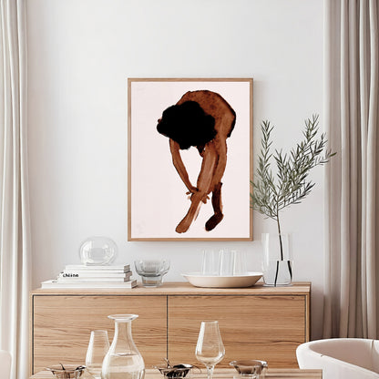 Framed artwork of a person in a crouched position on a wall above a wooden cabinet with glassware.