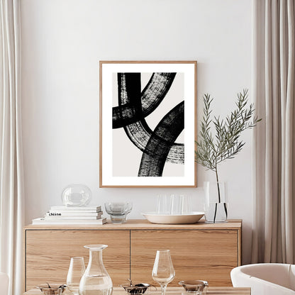 Framed abstract art on a wall above a wooden sideboard with decorative items.