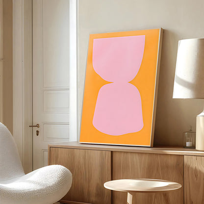 Abstract pink and orange artwork on a wall in a modern room with a chair and lamp.