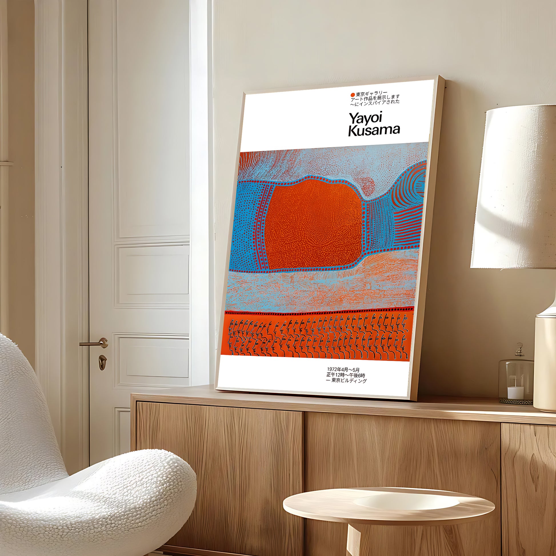 Artistic poster of Yayoi Kusama on a wall in a room with a chair and lamp.