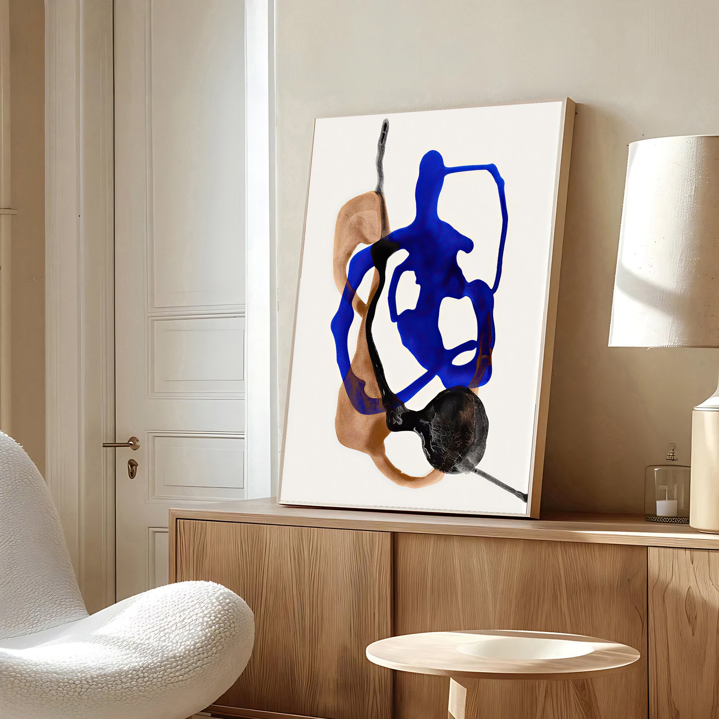Abstract art piece on a wall in a modern room with a chair and lamp.