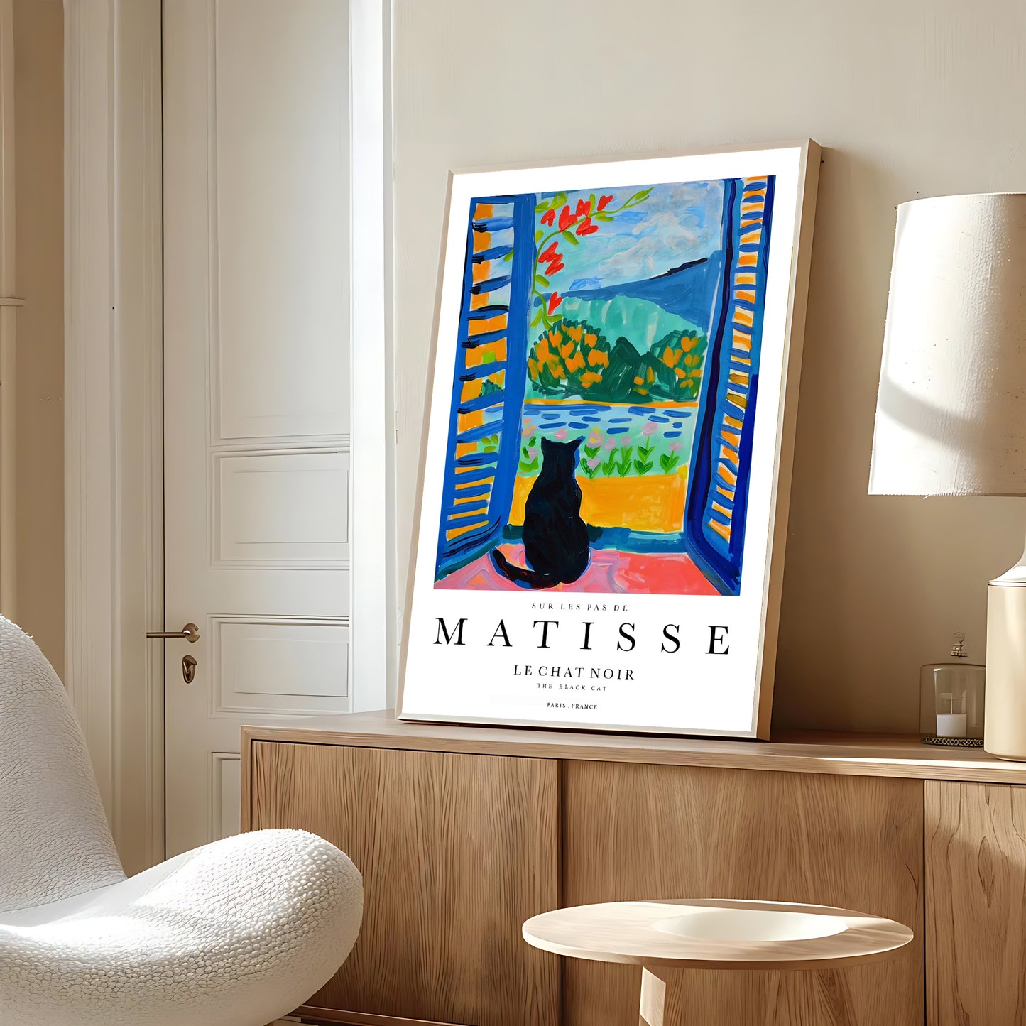 Framed Matisse art print on a wall in a room with a chair and lamp.