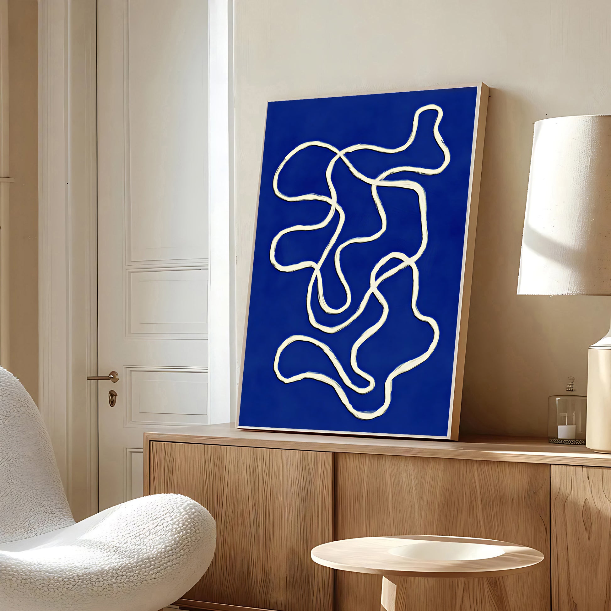 Abstract artwork with wavy lines on a blue background in a modern room.