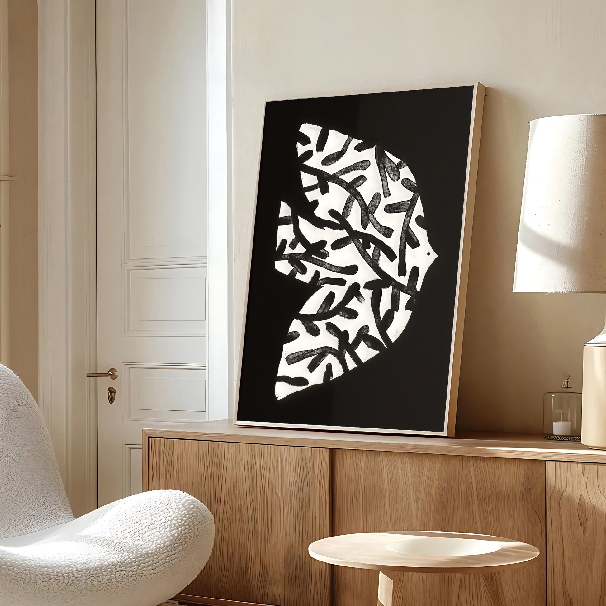 Modern interior with abstract black and white artwork on a wooden cabinet.