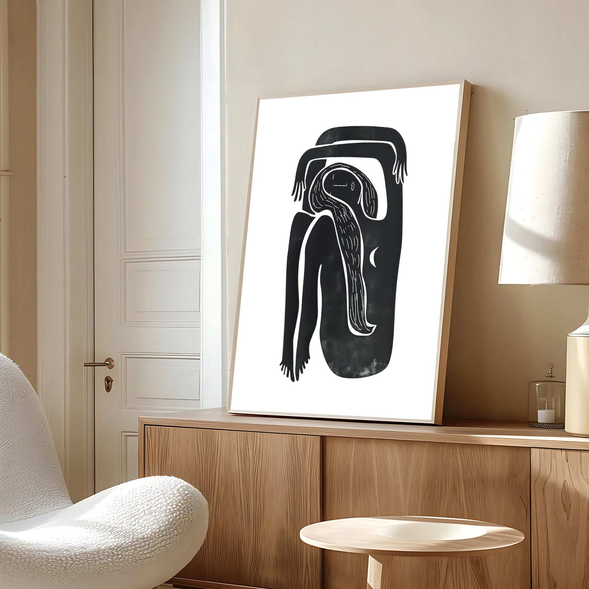Abstract black and white artwork on a wooden shelf in a modern room.