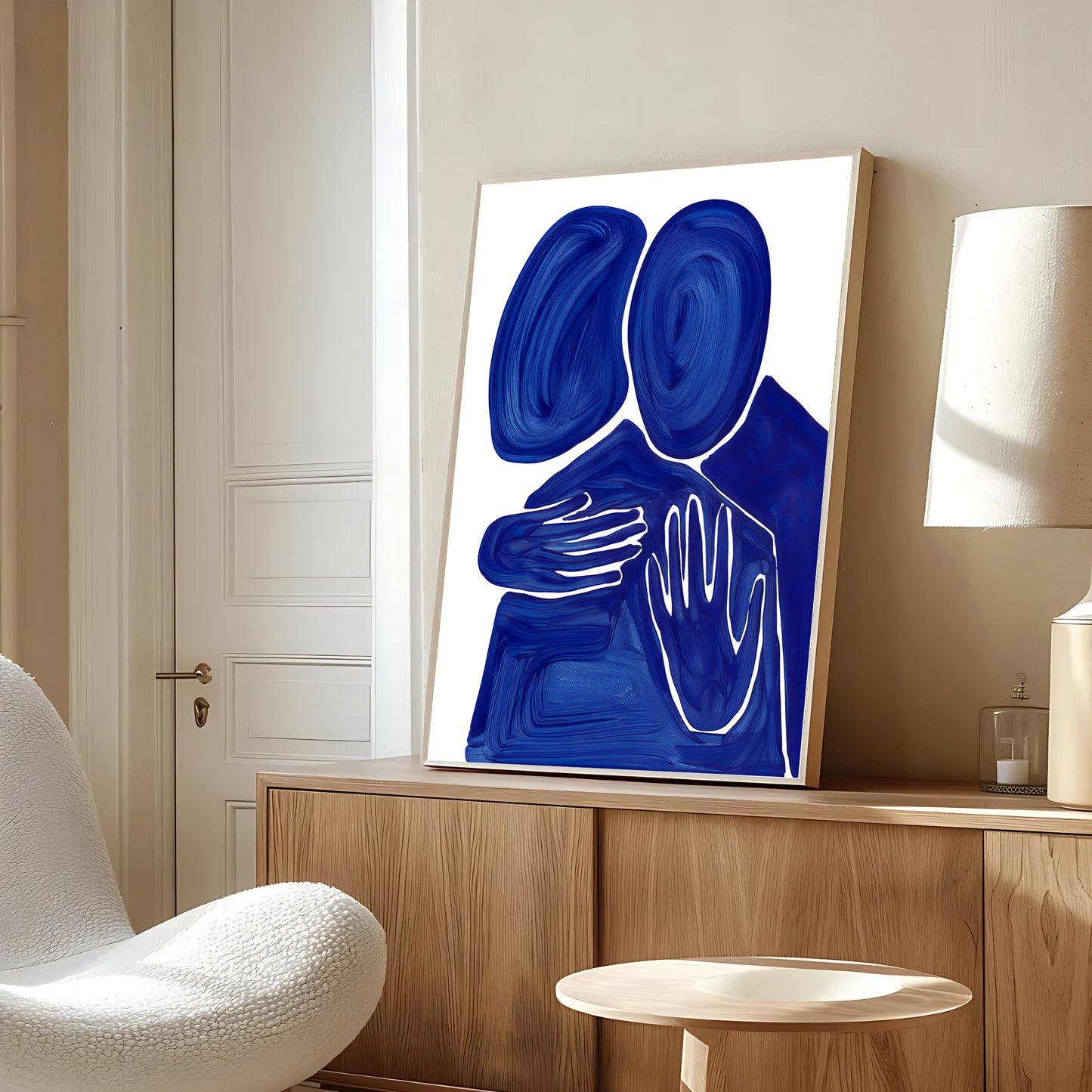 Abstract blue artwork on a wall in a modern room with a chair and lamp.