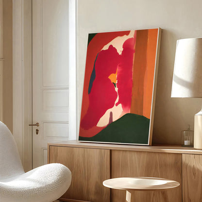 Abstract art piece on a wooden cabinet in a room with a white chair and lamp.