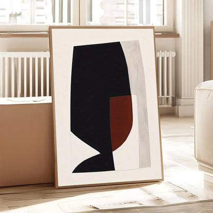 Framed abstract art piece on a light wooden floor with a neutral background