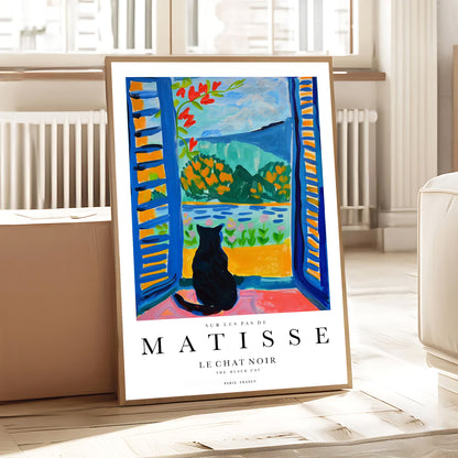 Framed Matisse art print of a black cat by a window in a room.