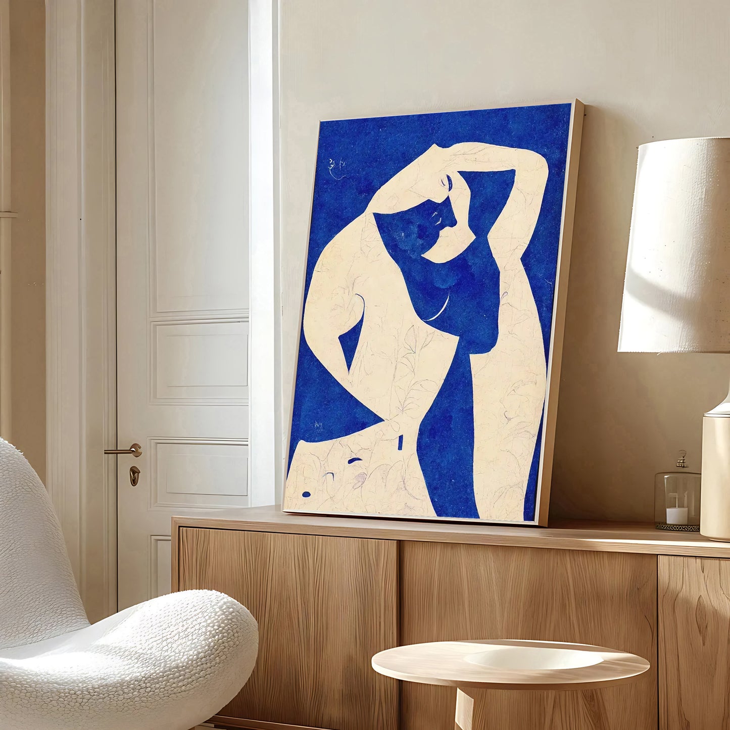 Modern interior with a blue and white abstract painting of a nude figure on a wooden cabinet.