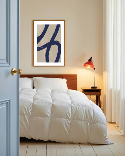 Bedroom with white bedding, wooden headboard, and abstract art on wall.